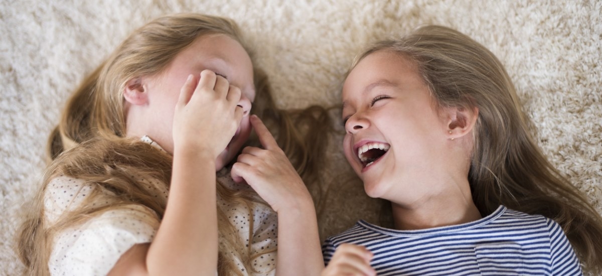 girls laughing on carpet